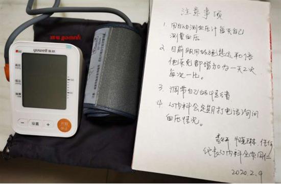 医院赠送的自动血压计和手写的大字版注意事项。